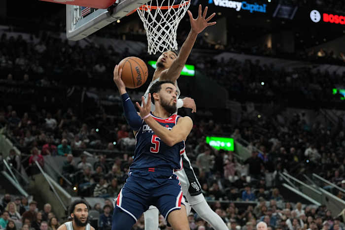 Washington Wizards guard Tyus Jones (5) looks to pass under the arm of San Antonio Spurs center Victor Wembanyama (1) in the second half at Frost Bank Center in San Antonio on Jan. 29, 2024.